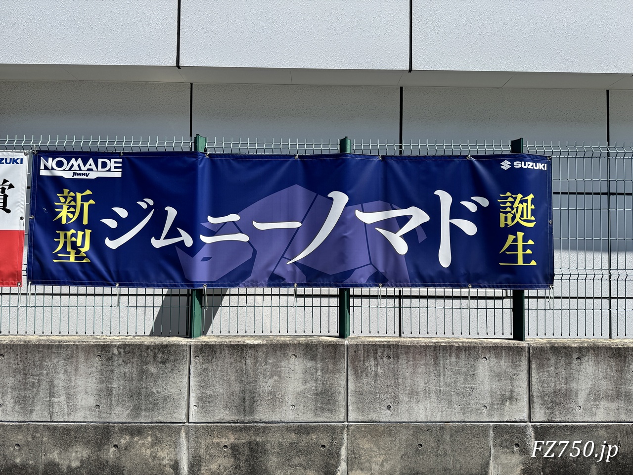 「新型 ジムニーノマド 誕生」と書かれた横断幕