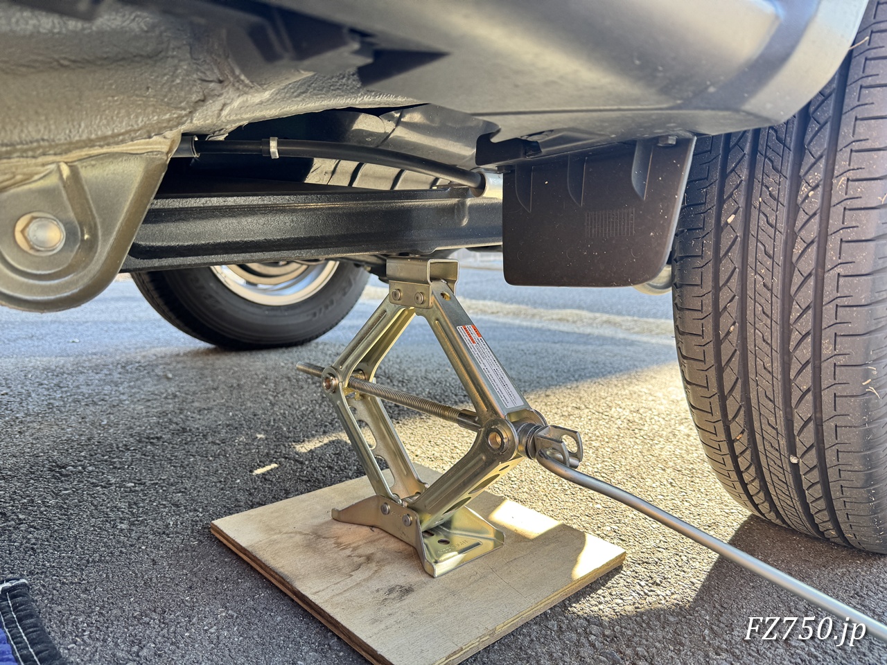 ジャッキ上部が左後輪のサスペンションアームのボス部分にはまることを確認してからジャッキアップする