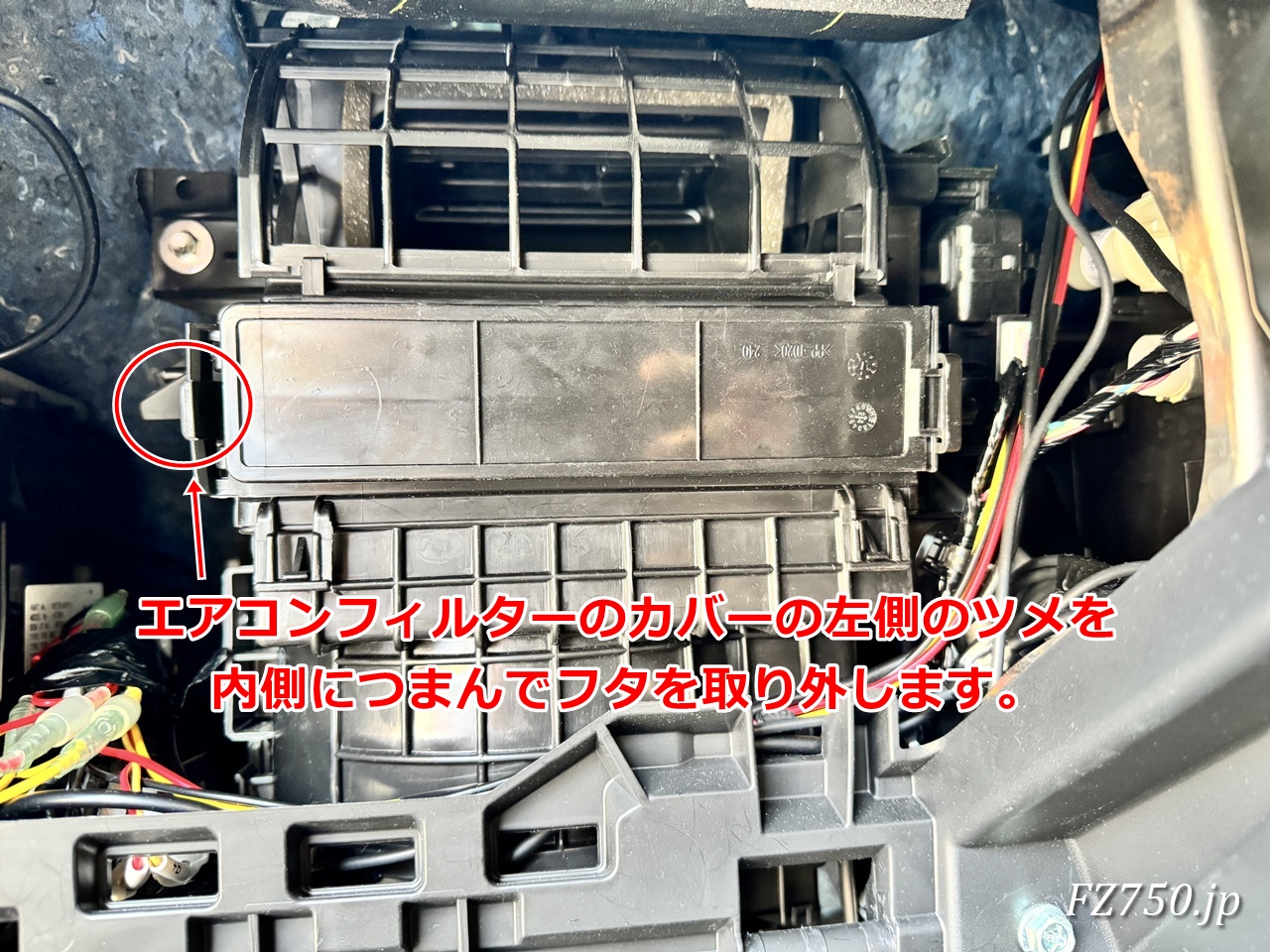エアコンフィルターのカバーの左側にあるツメを内側につまむようにすると、ロックが外れてカバーを取り外せる